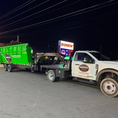 A roll off dumpster loaded on the trailer for a late delivery